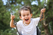 boy child swinging on a swing 