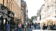 people walking on sidewalks in a European city 