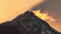 Time lapse Golden light of sun at beautiful sunrise over rocky peak in alps mountain nature
