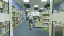 a boy walking into a library  