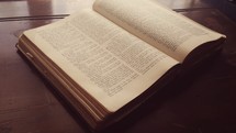 Open Bible lying on an antique desk