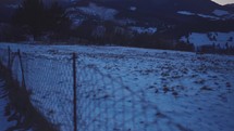 Reveal winter mountains behind fence in cold winter nature at blue hour before sunrise

