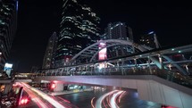 Timelapse of busy road and pedestrian overpass in night 