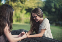 teen girls holding hands in prayer 