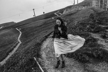 a woman walking on a windy mountainside 