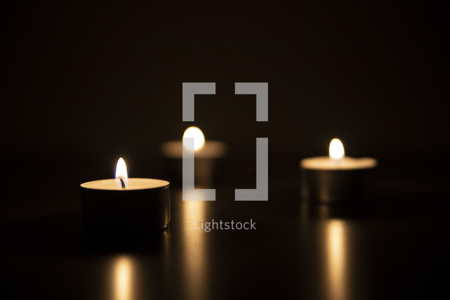 votive candles and candlelight in darkness 