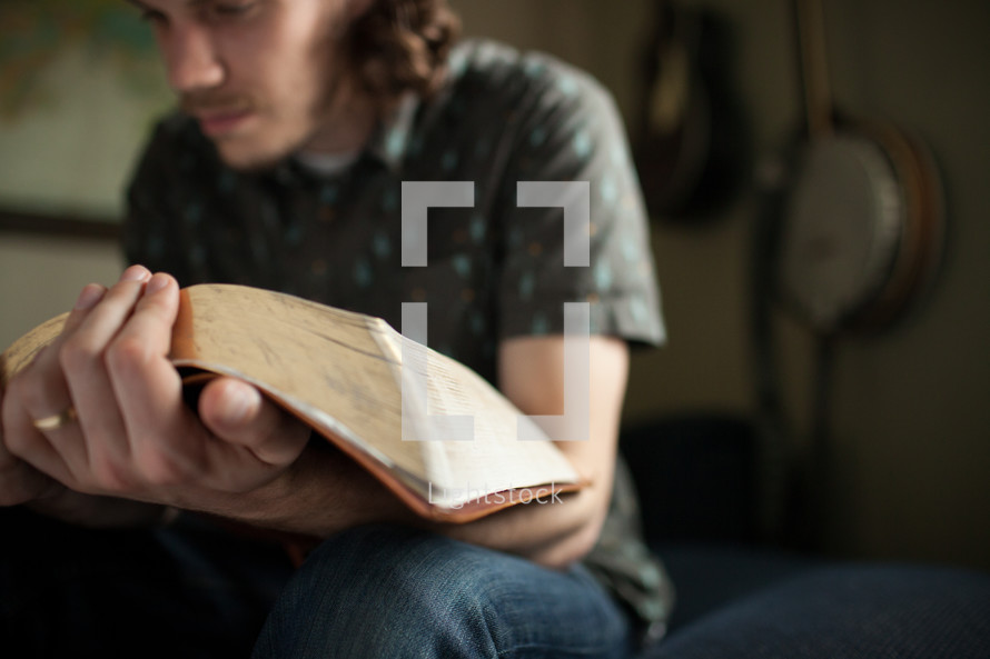 a man reading an oversized Bible 