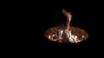 flames in a fire pit at night 