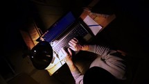 A computer hacker cracking passwords from a dark basement