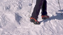 Slow motion of Tourist's feet hiking in crampons in snow ice mountain nature in sunny day active adventure
