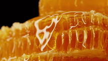 Raw honeycombs with pouring pure golden honey elixir. 