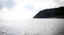 A backlit island seen from the ocean 