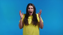 Woman afraid of something, she in shock on yellow backdrop. Holding head, screaming. High quality HD