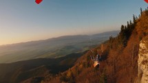 Peaceful paragliding fly above autumn forest nature mountains at beautiful sunset Freedom Adrenaline sport adventure
