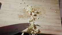 Chopped Garlic Falling From Wooden Board. Slow Motion Shot