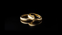 Wedding rings on a black background with reflection, studio shot