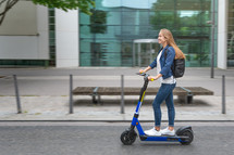 woman riding a scooter in a city 