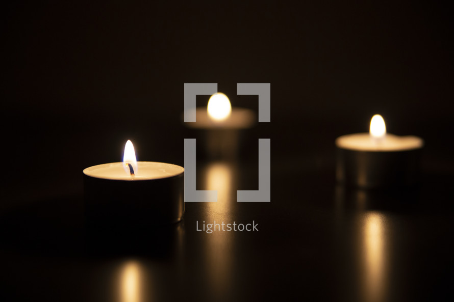 votive candles and candlelight in darkness 