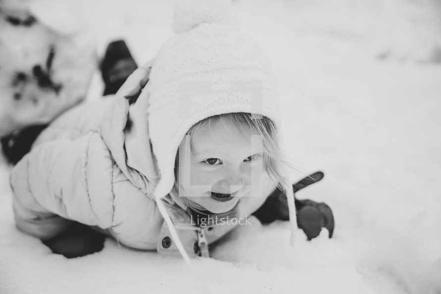 a toddler girl outdoors in snow 