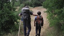 father and son hiking on a trail