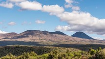 Sunny day with clouds over volcanic mountains in Tongariro National Park in New Zealand nature time-lapse
