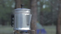 Coffee brewing on a camp stove in the forest