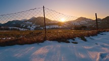 Golden sunrise in spring countryside landscape, reveal over old fence
