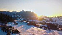 Colors of sunset over winter mountains and rural country Aerial view
