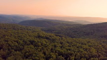 Colorful sunset over forest mountains landscape in summer evening.
