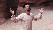 a man kneeling in prayer in the desert 