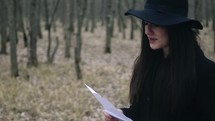 a woman running through a forest after reading a letter 