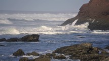 Waves on rocky coast of ocean shore in sunny summer Morocco Nature Tourism Background