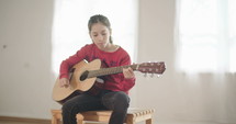 young girl playing guitar and singing