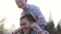 boy riding on father's shoulder 