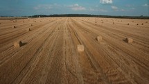 aerial view over hay bales in a plowed field 