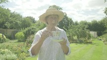 Senior caucasian woman drinking tea in her garden themes of retirement seniors relaxing drinking