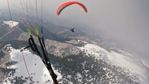 Paragliding over winter mountains.
