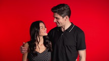 Portrait of young couple on red studio background