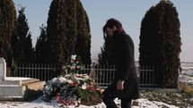a man with a rose visiting a grave 