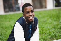 a smiling teen boy in a letter jacket 