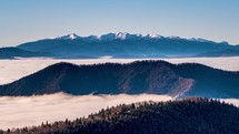 Panoramic view of alps mountains above foggy clouds motion fast in valley in cold winter morning nature Time lapse

