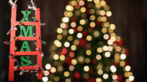 Christmas decoration ladder on blurred tree background