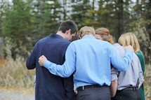 a group of young adults in a circle of prayer