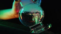 Glass water bong in neon light - drug paraphernalia