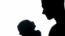 silhouette of a father holding a swaddled newborn 