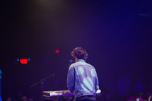 a musician playing an electric piano on stage 