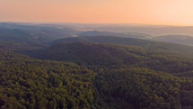 Aerial evening colors over forest mountains country
