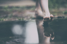 woman stepping into a puddle 
