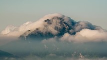 Time lapse of mountain peak with foggy clouds. 
