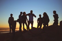 silhouette of friends on a mountain 